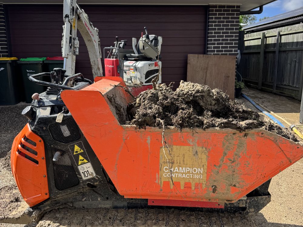 Tracked mini dumper loaded with soil on a residential job