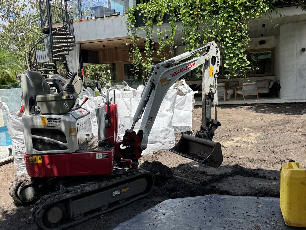 Mini excavator preparing a driveway on pavers
